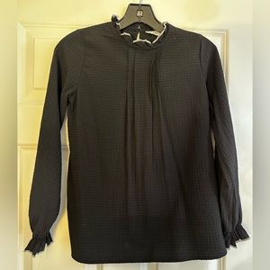Mango girls black blouse with white stitching on ruffle collar and cuffs.